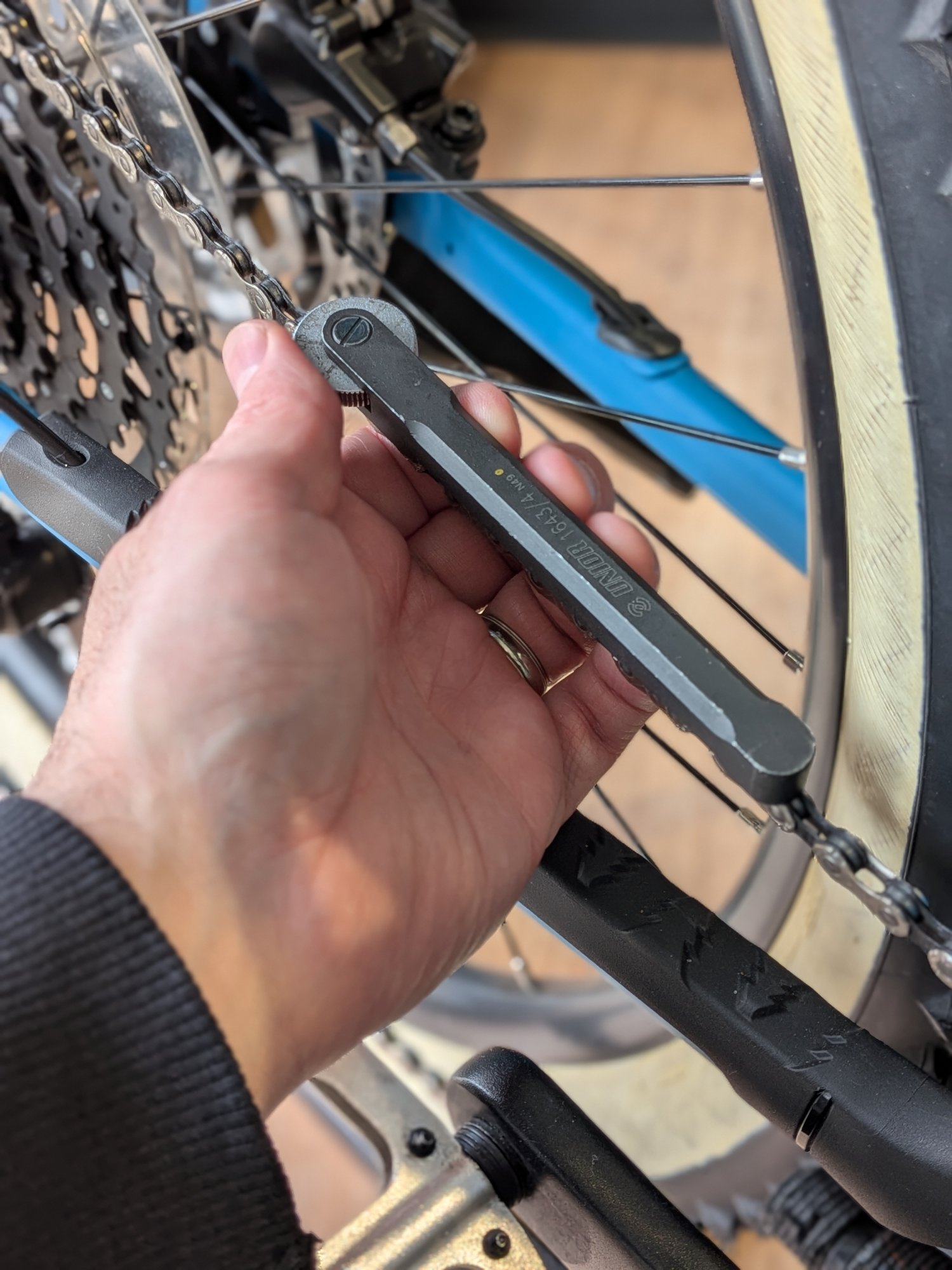 Bike Doctor technician checking chain wear with a chain wear indicator tool